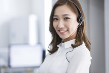 Cheerful Young Chinese Businesswoman With Headset In Office