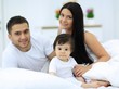 © ASDF - Cheerful family having fun together lying on a bed