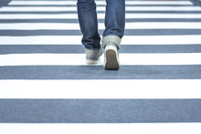 Man Wear Jeans Walk Across The Street On The Crosswalk