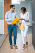 © Bojan - Two business people walking and discussing paperwork indoors
