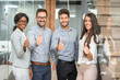© Bojan - Successful young business people showing thumbs up sign