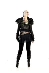 full length portrait of blonde girl wearing lack fantasy warrior outfit. standing pose wit bak to the camera. isolated on white studio background.