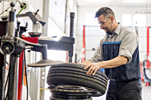 Cuadros en Lienzo Mechanic changing car tire at work
