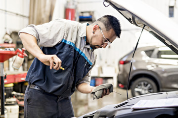 Handsome mechanic job in uniform working on car