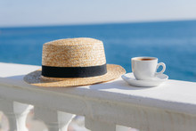 Cup Of Coffee Next To A Straw Hat On A Wall