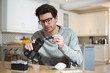 © Wavebreak Media - Man cleaning lens of digital camera at home