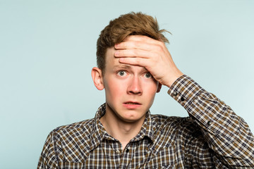 Wall Mural - omg unbelievable shock amazement. dumbfounded man with open mouth clutching his head. portrait of a young guy on light background. emotion facial expression and reaction concept.