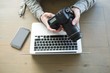 © Wavebreak Media - Man using digital camera at home