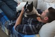 © Wavebreak Media - Man playing with his pet dog in living room