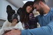 © Wavebreak Media - Couple playing with their pet dog in kitchen at home