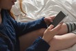 © Wavebreak Media - Woman using mobile phone in bedroom