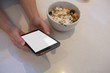 © Wavebreak Media - Woman using mobile phone in kitchen at home