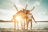 Fototapeta  - Happiness Friends stay in group on the beach under sunset sunlight