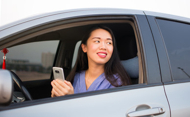 Wall Mural - Asian girl using phone in car