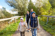 © Syda Productions - family, tourism and hiking concept - happy mother, father, son and daughter with backpacks walking in woods