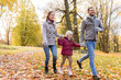 © Syda Productions - family, season and people concept - happy mother, father and little daughter walking at autumn park