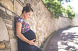 © Louis-Photo - Portrait of a happy and proud pregnant woman on urban background