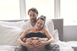 © Louis-Photo - Man with pregnant woman in bed at home having great time