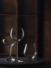 A Variety Of Wine Glasses In A Warm Rustic Setting On A Dark Granite Surface.