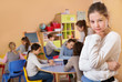 © JackF - Upset girl in schoolroom on background with pupils