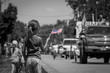Girl waving American flag at parade in black and white