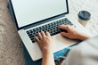 © verona_studio - Woman working on a laptop. Female using a laptop sitting on floor, searching web, browsing information, having workplace at home. The concept of blogging. Modern technologies. Top view.