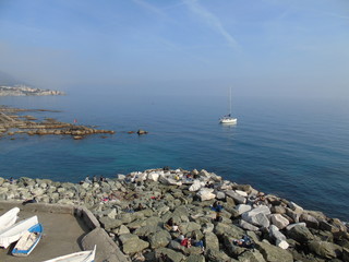 Beautiful caption of an amazing calm sea from Genova in summer days with some people enjoying the evening