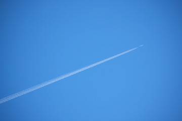 a streak of contrail and blue sky