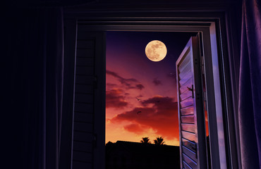 sunset and moonrise seen from an open window