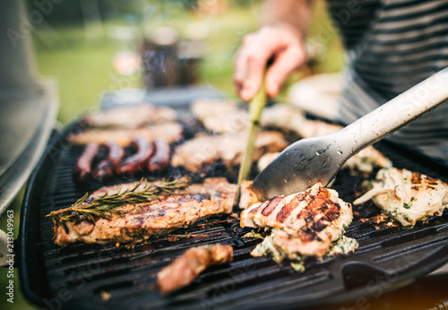 Fotomural Unrecognizable man cooking seafood on a barbecue grill in the backyard