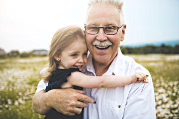 grandfather spending time with little child during the sunset.