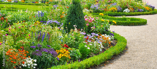 Lush flower beds in the summer garden.Wide photo. © alinamd