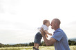© Louis-Paul Photo - little boy and his father enjoying outdoors in field of daisy flowers