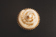 Top view of vanilla cupcake with white frosting and gold sprinkles