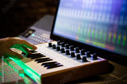 Fotografía composer hands playing midi keyboard for recording song on computer in home stud