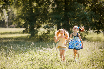 Wall Mural - two beautiful young joyful jumping girls in the summer in the park