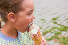A Little Girl Is Eating Ice Cream.