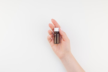 Woman hand with small glass bottle isolated