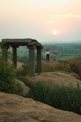 Fototapete - Picturesque view from the Malyavanta Hill at sunset overcast sky in Hampi, Karnataka, India. Tourists enjoy and photograph the sunset