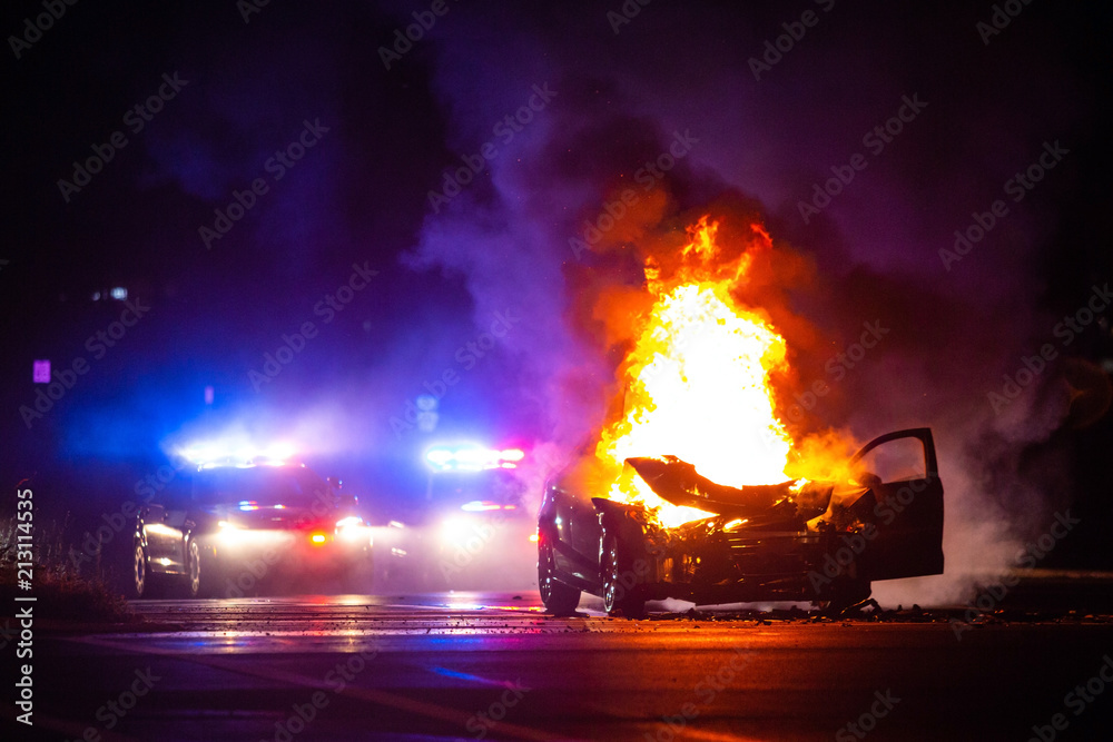 Car on fire at night with police lights in background Stock Photo ...
