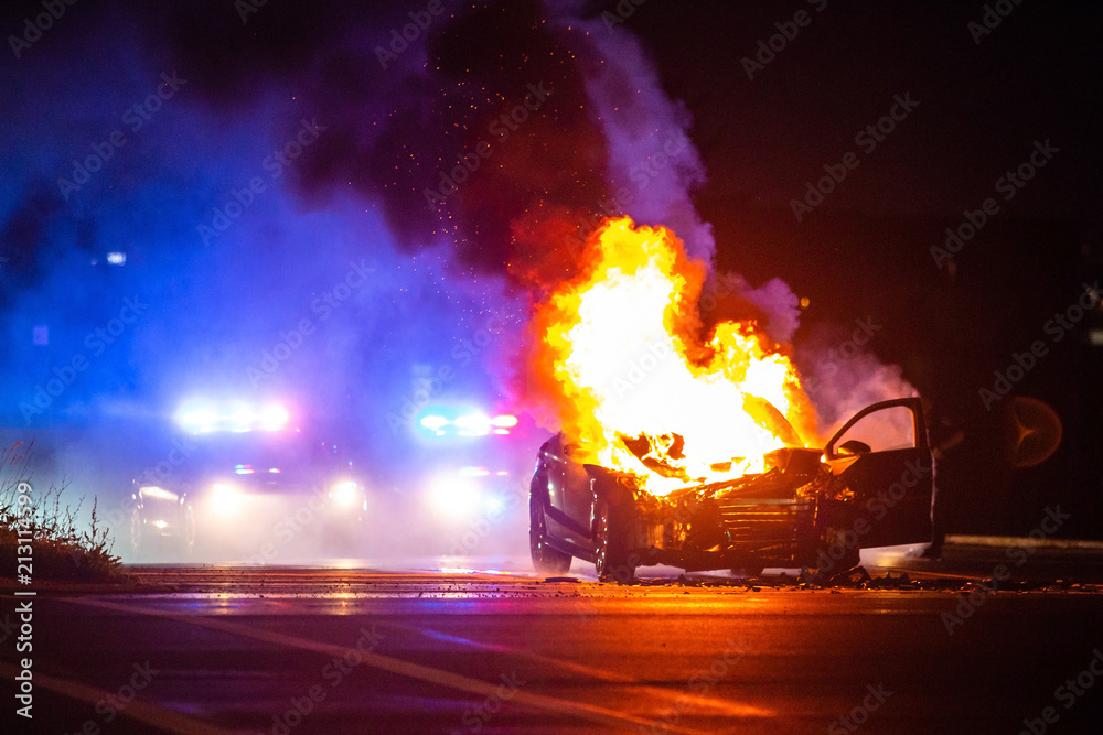 Car on fire at night with police lights in background Stock Photo ...