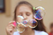 © taraskobryn - young girl blowing bubbles blurry