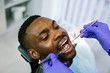 © sofiko14 - African male patient getting dental treatment in dental clinic