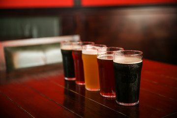 Canvas Print - Glasses of different beer on table indoors