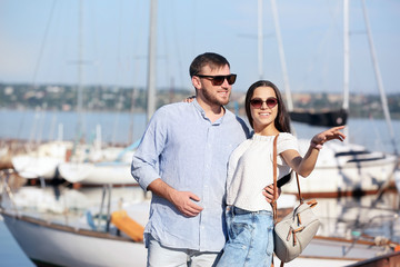 Wall Mural - Young hipster couple in jean clothes on pier