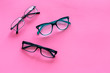 © 9dreamstudio - Glasses concept. Set of glasses with different eyeglass frame and transparent lenses on pink background top view copy space