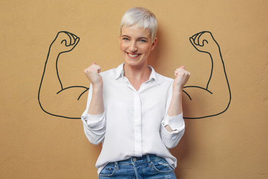 blond frau an der wand / muskeln / kraft / power