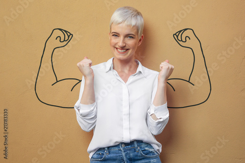 Fotomural Blond Frau an der Wand / Muskeln / Kraft / Power