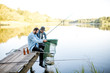 © rh2010 - Two happy male friends looking at the fishing net with fish during the fishing on the lake