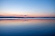 soft and calm sunset at Balaton lake in summer - thin clouds, velvet waves on water and hills in background